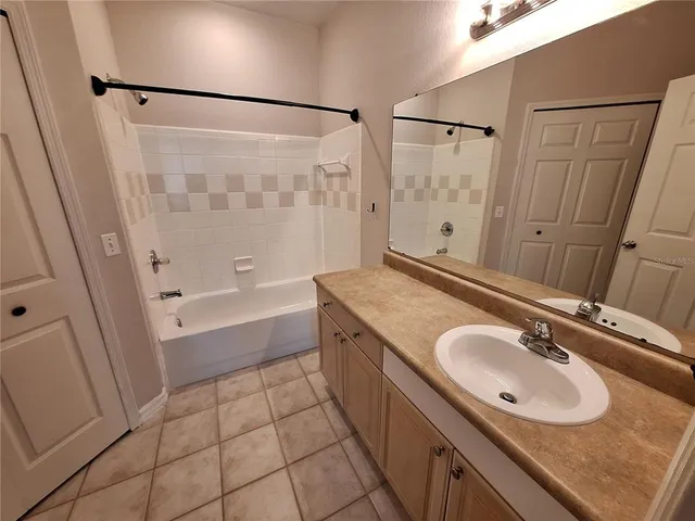 a bathroom with a granite countertop sink a mirror and shower