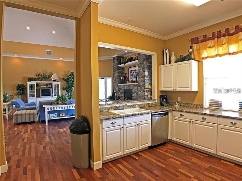 5550 Rosehill Road, Unit 103 Sarasota, FL 34233 - Photo 26 of 28 a kitchen with a sink and wooden floor