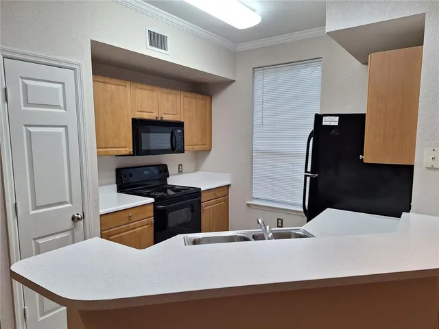 a kitchen with a refrigerator and a stove top oven