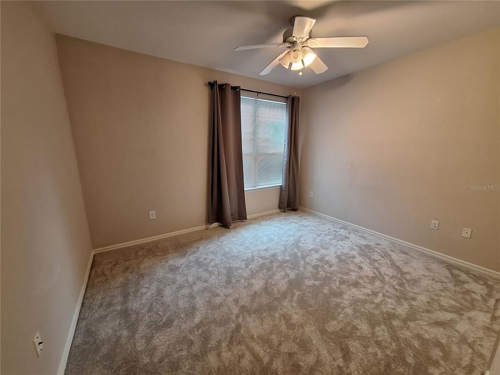 5550 Rosehill Road, Unit 103 Sarasota, FL 34233 - Photo 10 of 28 en empty room with windows and fan