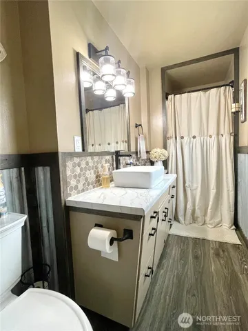 a bathroom with a granite countertop sink toilet and mirror