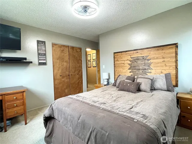 a bedroom with a bed and large windows