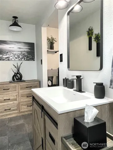 a bathroom with a sink a toilet and mirror