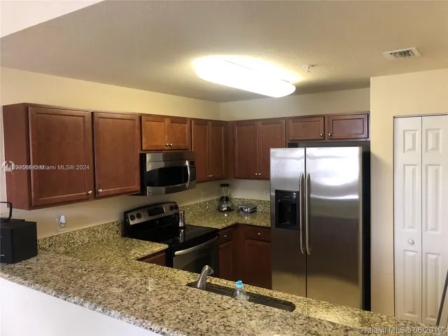a kitchen with a refrigerator sink and stove