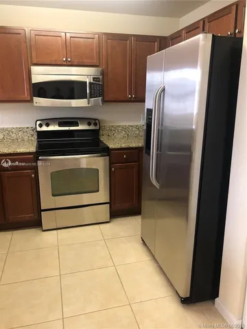 a kitchen with granite countertop a refrigerator and a stove