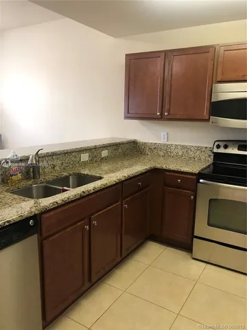 a kitchen with granite countertop a sink and cabinets