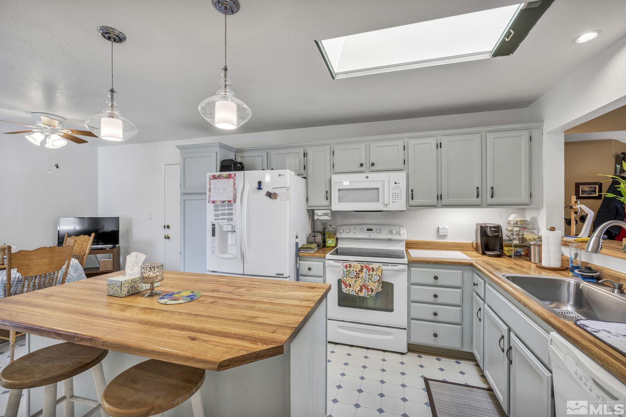 17575 Blackbird Drive Reno, NV 89508 - Photo 12 of 29 a kitchen with stainless steel appliances kitchen island granite countertop a sink a stove and a refrigerator