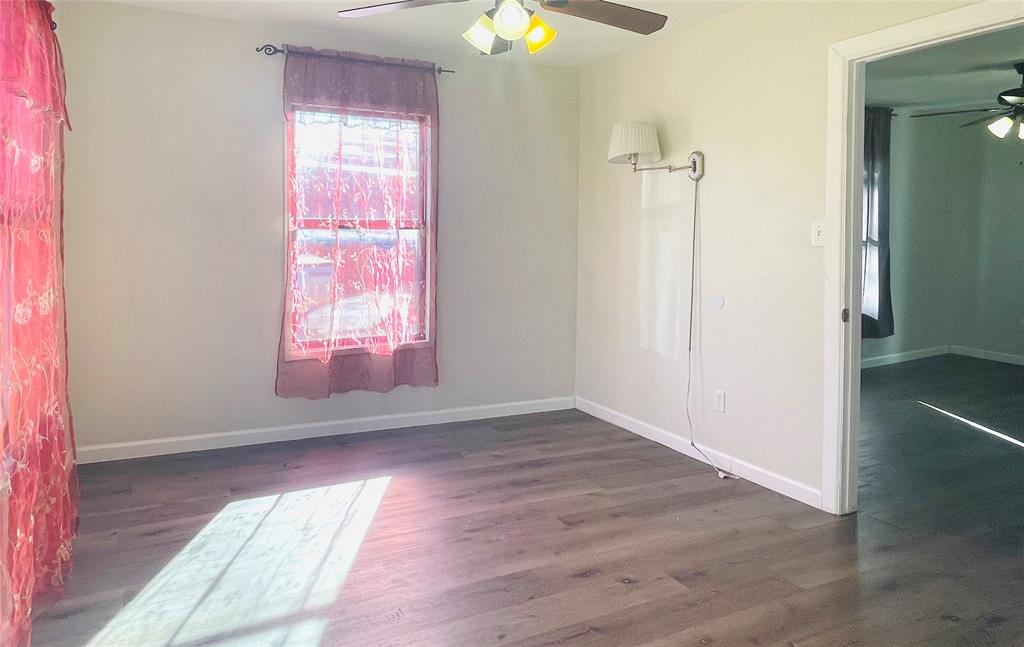 111 Rousseau Street Waxahachie, TX 75165 - Photo 8 of 22 an empty room with wooden floor and windows