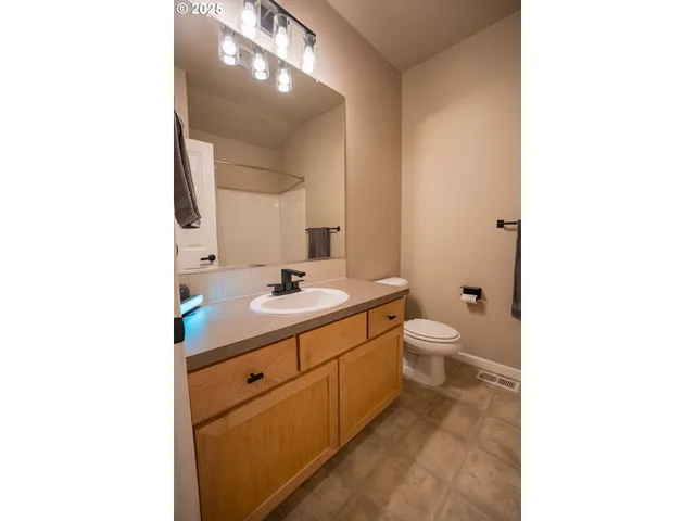 a bathroom with a toilet a sink a mirror and a shower