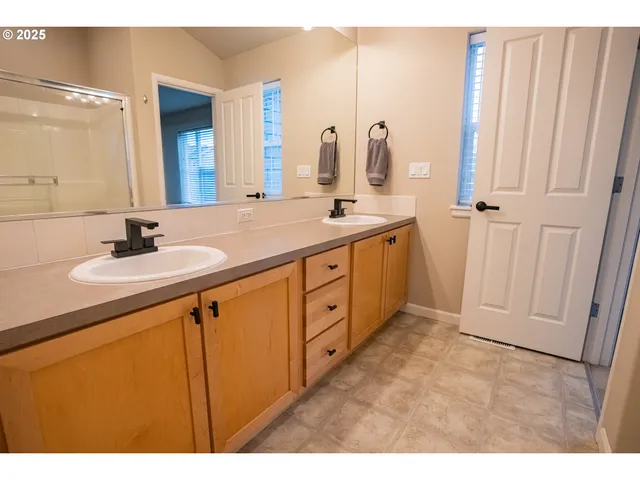a bathroom with a double vanity sink and mirror