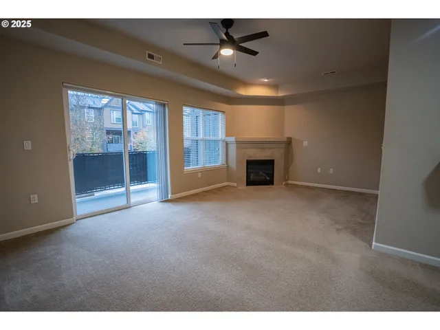 a view of empty room with fireplace and fan