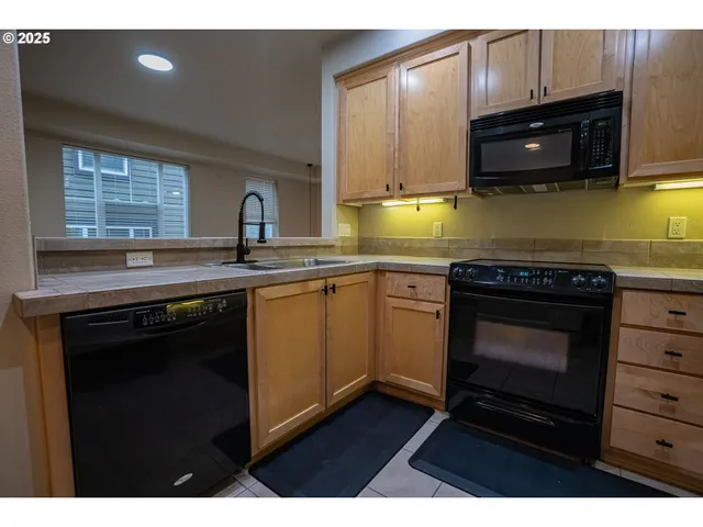 a kitchen with stainless steel appliances a stove a sink and a microwave