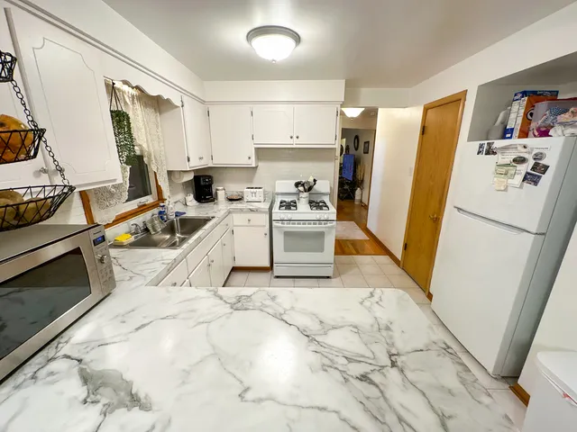 a view of a kitchen with sink and refrigerator