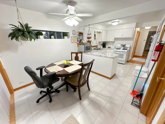 a view of a dining room with furniture and a chandelier fan