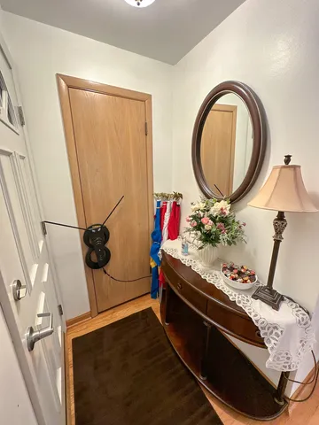 a living room with a bed and a dresser with wooden floor