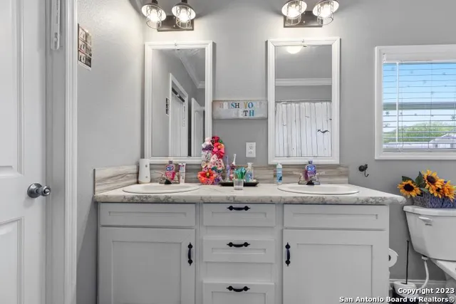 a bathroom with a sink vanity mirror and toilet