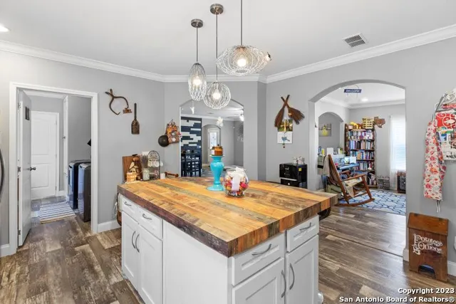 a living room with kitchen island furniture and a chandelier