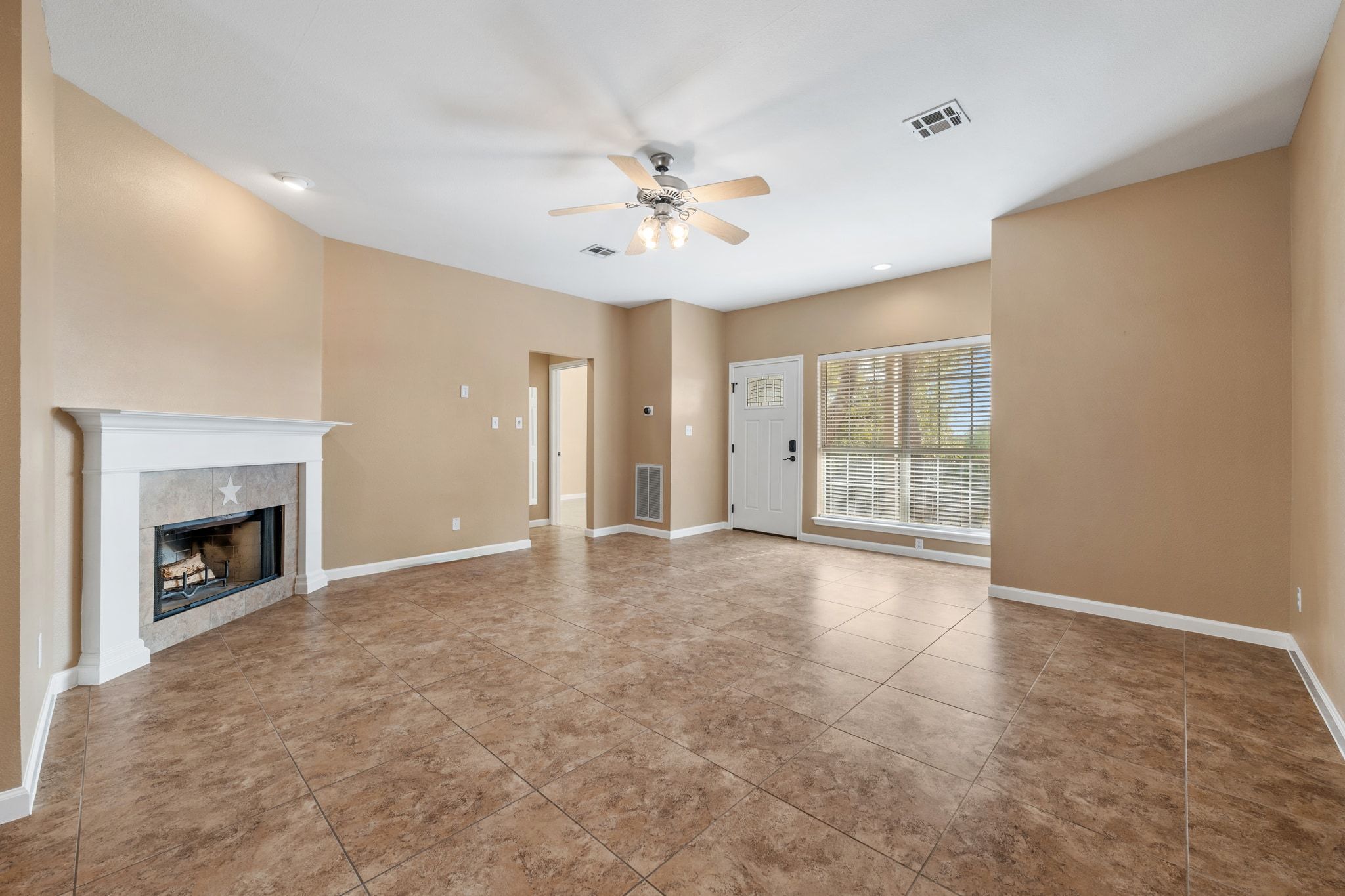 3139 Chisholm Trail Austin, TX 78734 - Photo 12 of 37 Unfurnished living room with a ceiling fan, a tile fireplace, light tile patterned floors, and recessed lighting