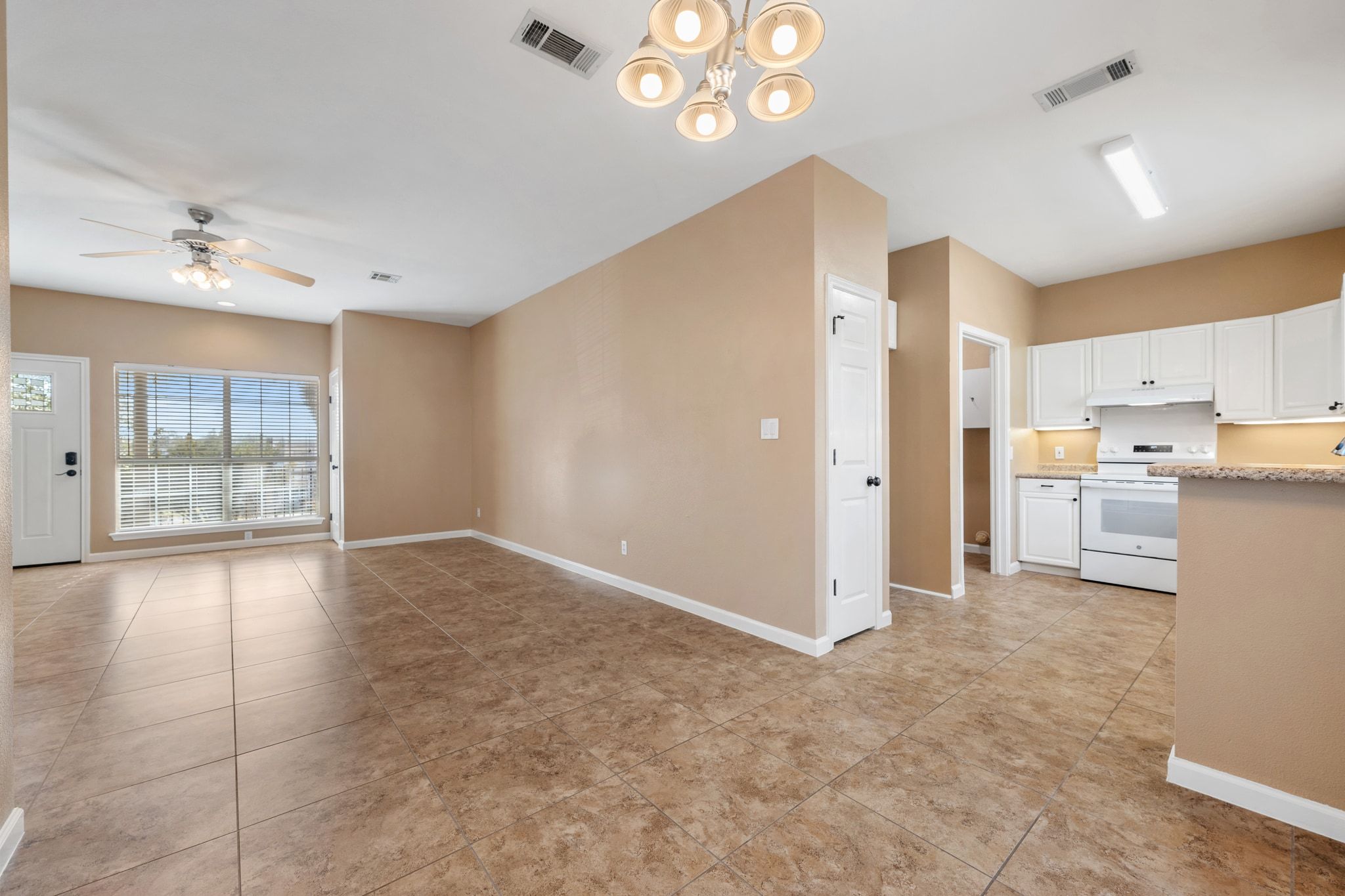 3139 Chisholm Trail Austin, TX 78734 - Photo 37 of 37 Kitchen with white range oven, a ceiling fan, white cabinetry, open floor plan, and light tile patterned floors