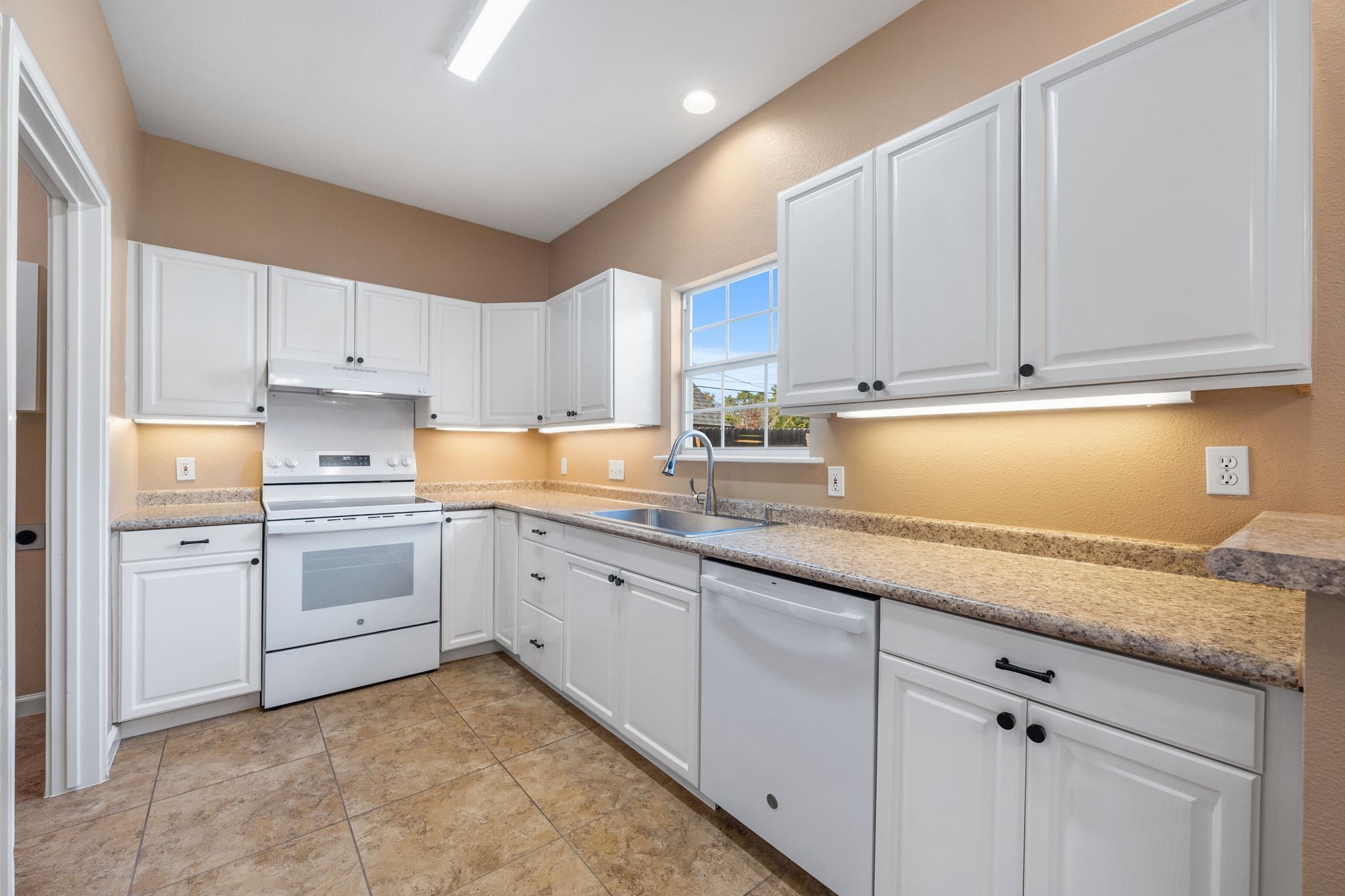 3139 Chisholm Trail Austin, TX 78734 - Photo 17 of 37 Kitchen featuring white appliances, white cabinets, and light countertops