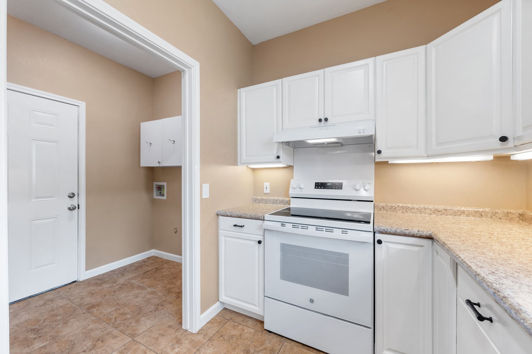 3139 Chisholm Trail Austin, TX 78734 - Photo 18 of 37 Kitchen with white electric range oven, white cabinetry, light stone countertops, and light tile patterned floors