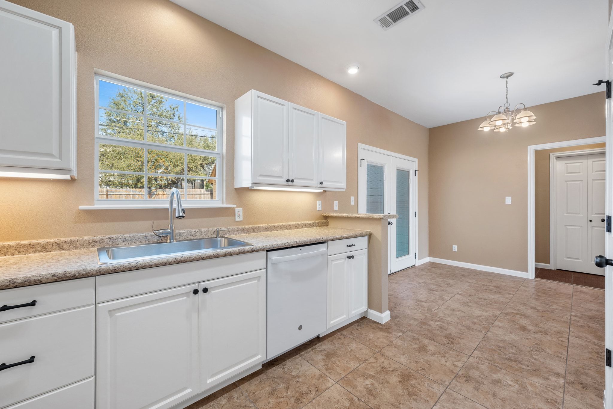 3139 Chisholm Trail Austin, TX 78734 - Photo 20 of 37 Kitchen featuring white cabinetry, white dishwasher, and suspended lighting