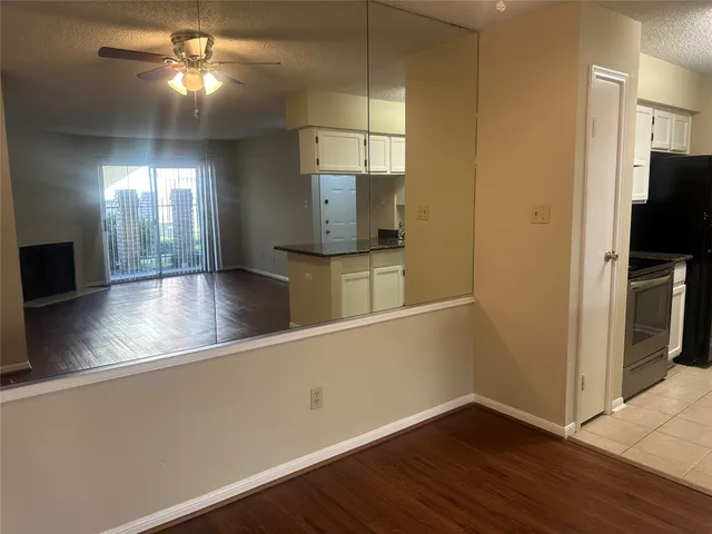 a view of a kitchen with furniture and stainless steel appliances