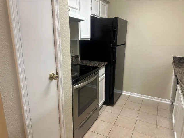 a kitchen with a refrigerator and cabinets