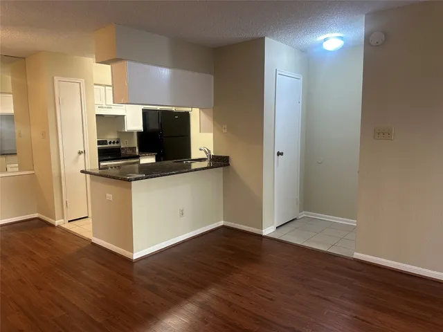 a view of kitchen with wooden floor and electronic appliances