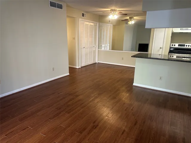 a view of a kitchen with a flat screen tv and wooden floor