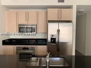 a kitchen with cabinets and stainless steel appliances