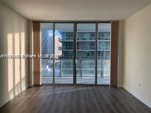 1111 Southwest 1st Avenue, Unit 2316N Miami, FL 33130 - Photo 7 of 37 an empty room with wooden floor and windows