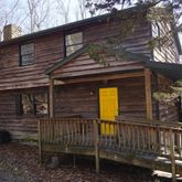 a view of a house with backyard and wooden fence