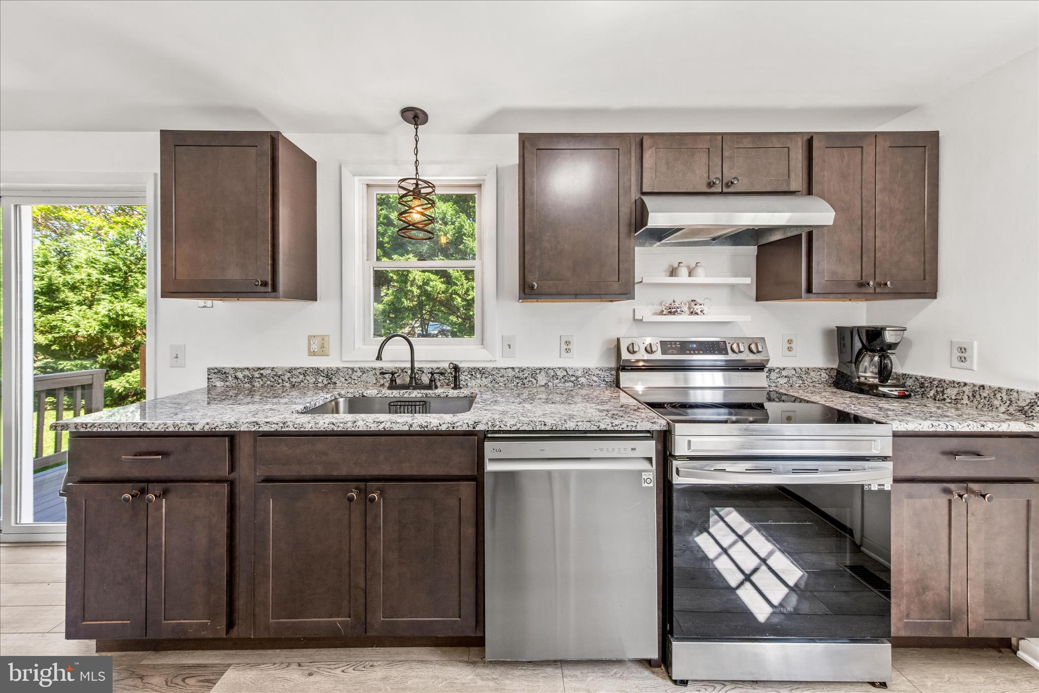 21406 Dogwood Cove Road Tilghman, MD 21671 - Photo 29 of 68 a kitchen with kitchen island granite countertop wooden cabinets and a sink