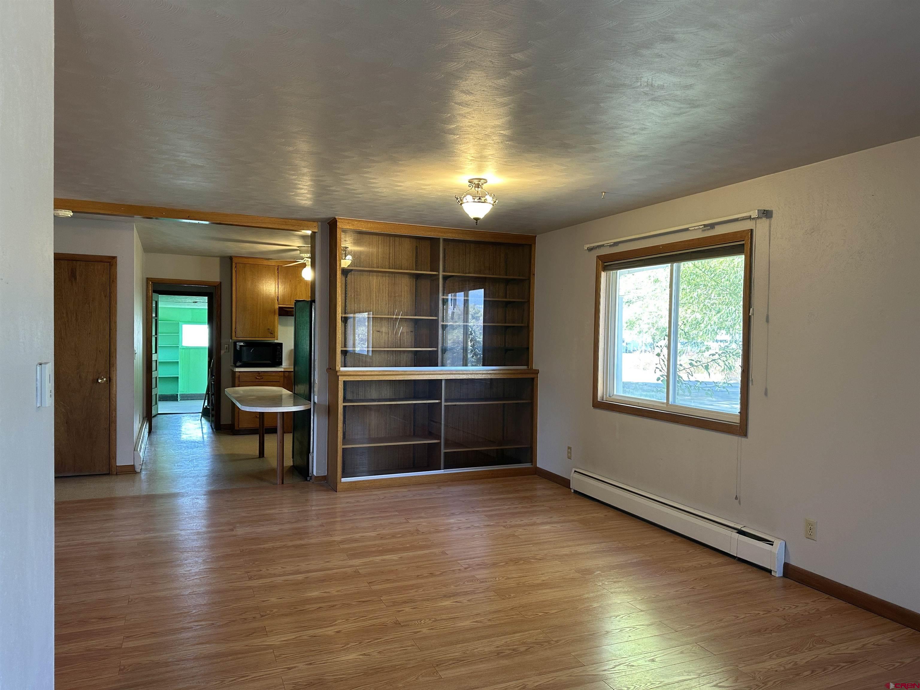 1090 Cloverleaf Lane Delta, CO 81416 - Photo 14 of 30 an empty room with wooden floor and windows
