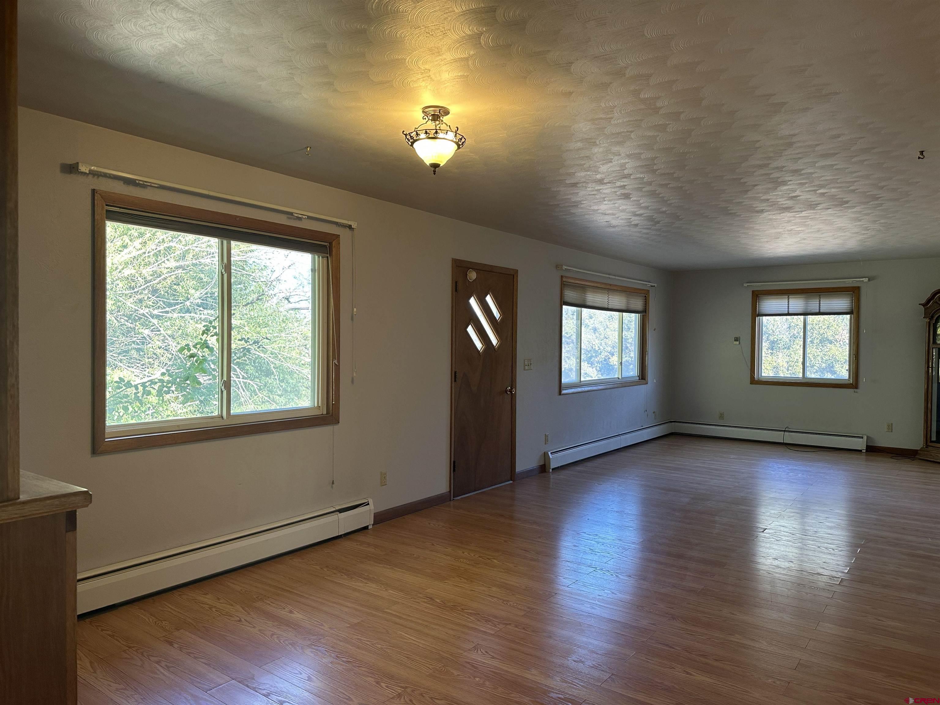 1090 Cloverleaf Lane Delta, CO 81416 - Photo 6 of 30 an empty room with wooden floor and windows
