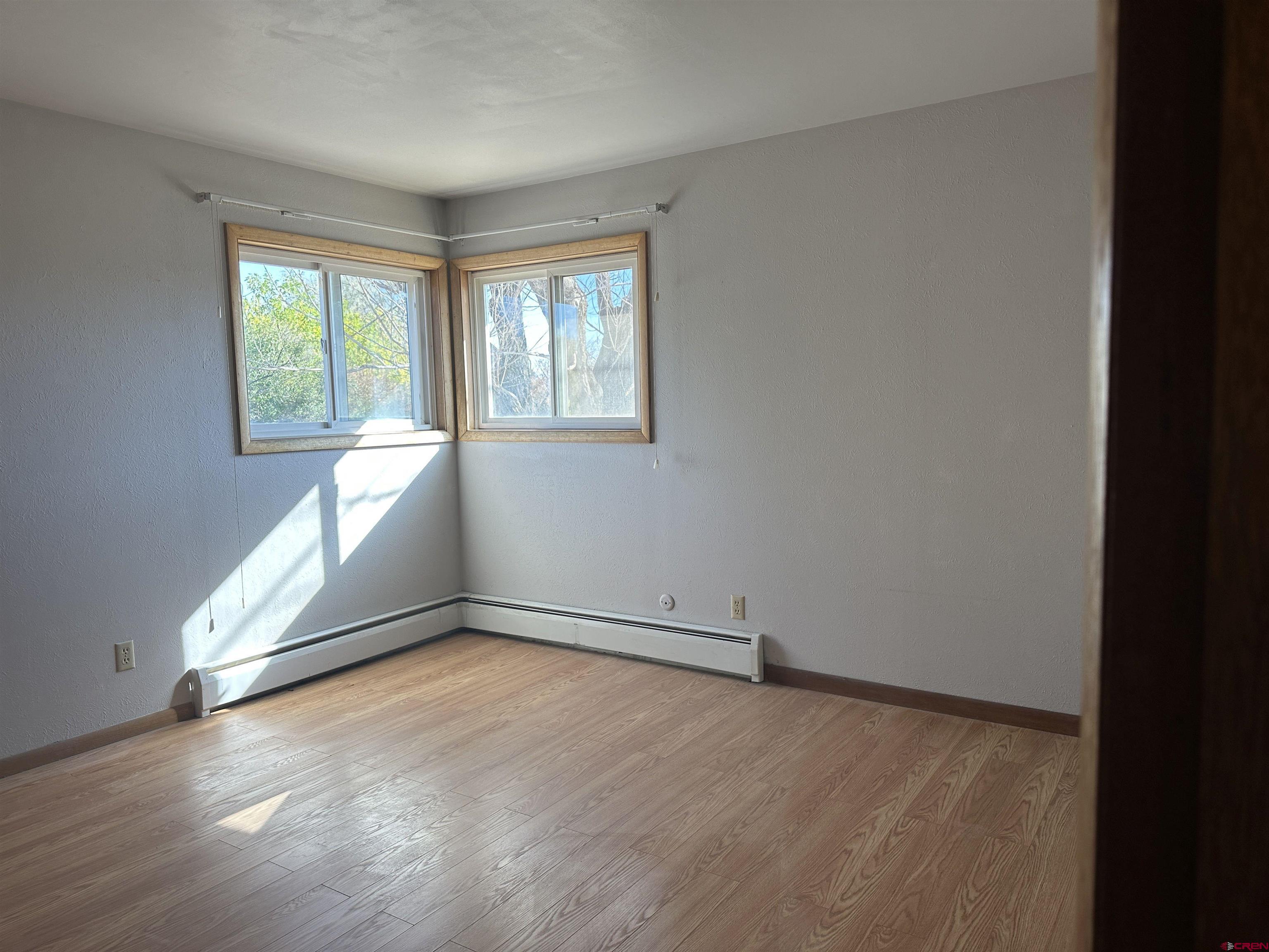 1090 Cloverleaf Lane Delta, CO 81416 - Photo 10 of 30 an empty room with wooden floor and windows