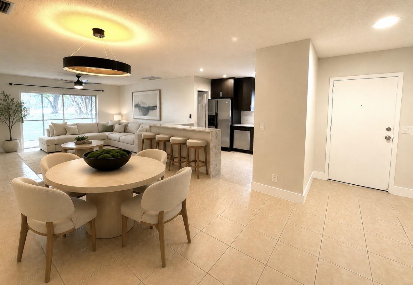 22324 Southwest 57th Circle Boca Raton, FL 33428 - Photo 1 of 22 a kitchen with stainless steel appliances granite countertop a table chairs and a refrigerator