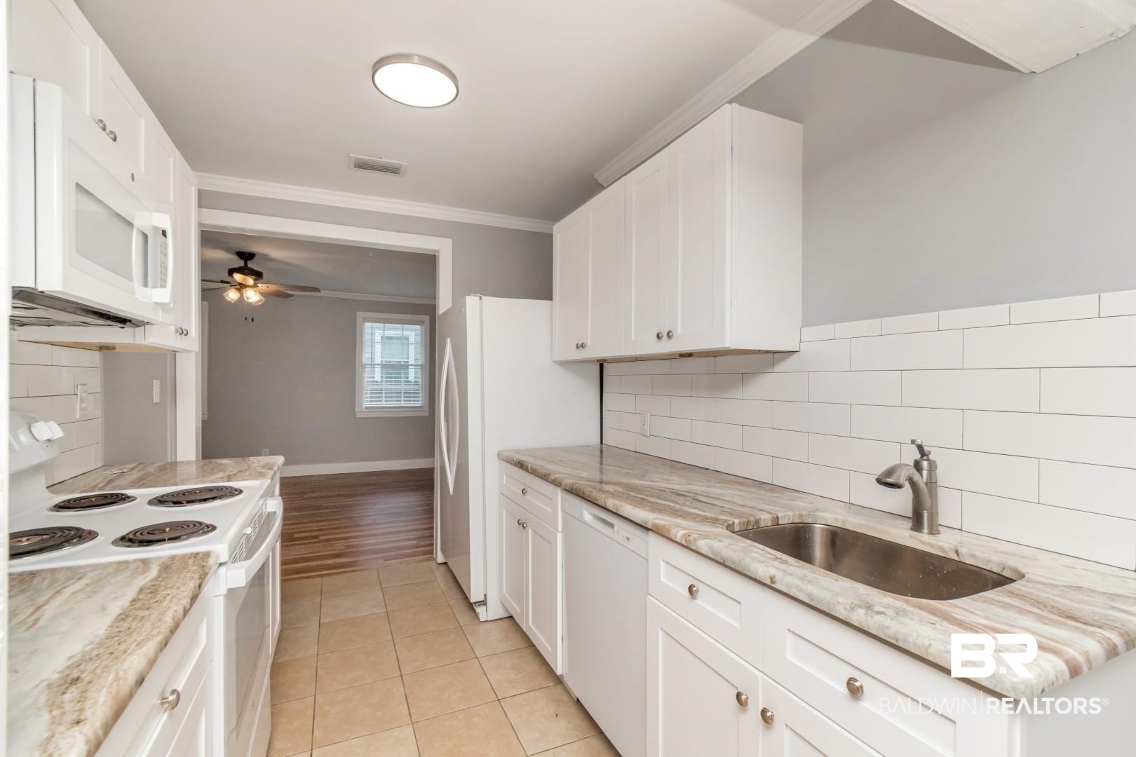 263 Border Drive East Mobile, AL 36608 - Photo 13 of 27 Kitchen featuring white cabinetry, light-toned countertops, a stainless steel sink, and a white subway tile backsplash