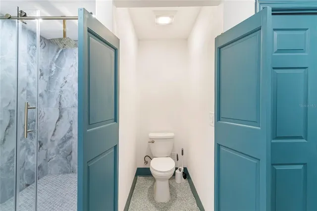 a bathroom with a toilet and a shower