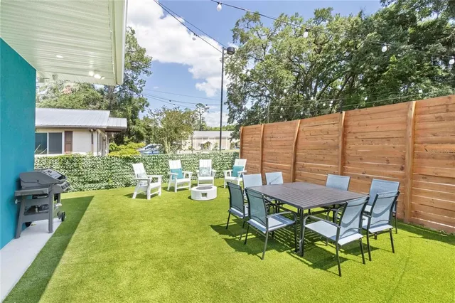 a view of a backyard with table and chairs and potted plants