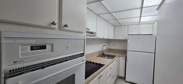 a kitchen with granite countertop a sink and a stove top oven