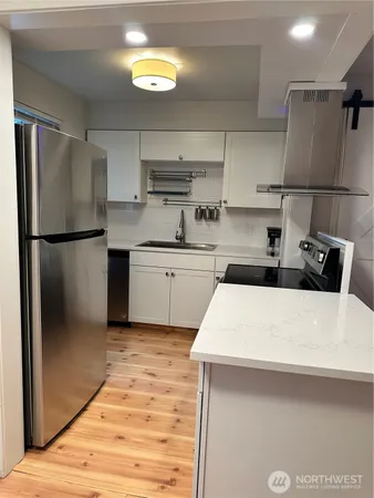a kitchen with stainless steel appliances a refrigerator sink and microwave