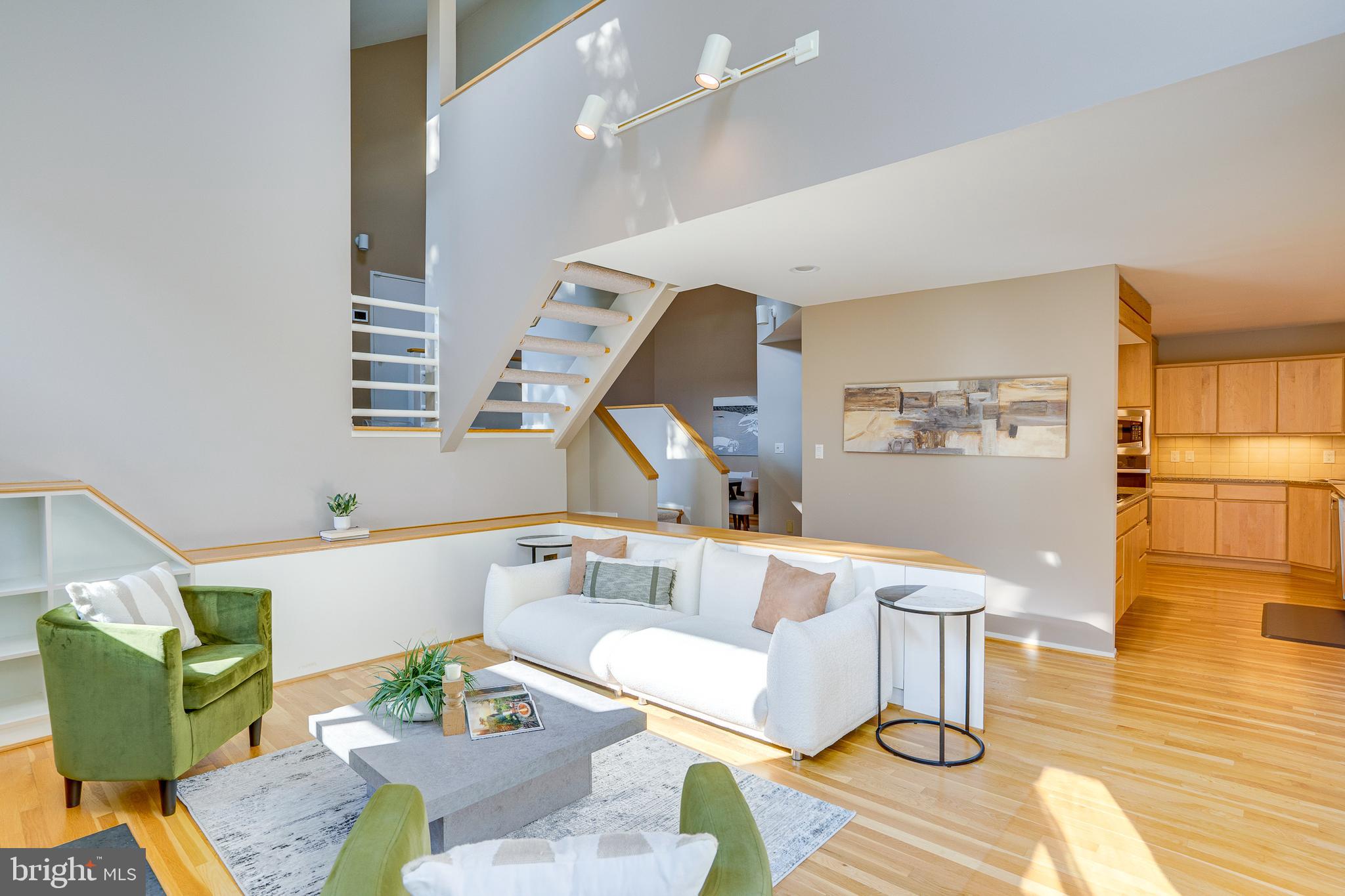 2148 South Bay Lane Reston, VA 20191 - Photo 13 of 73 a living room with couches and kitchen view with wooden floor