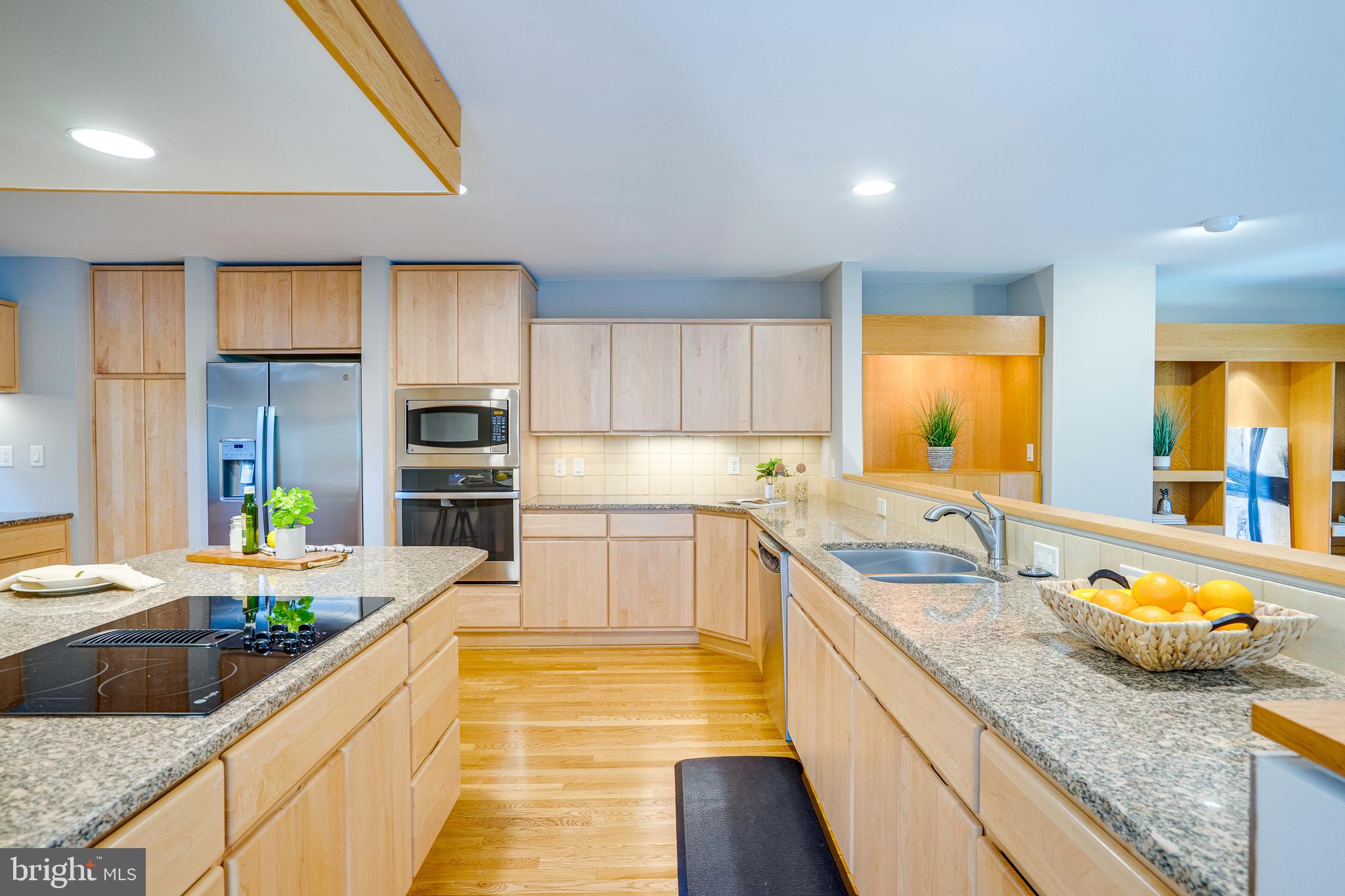 2148 South Bay Lane Reston, VA 20191 - Photo 31 of 73 a large kitchen with granite countertop a sink and dishwasher a stove top oven with wooden floor