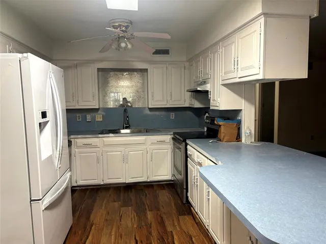 a kitchen with stainless steel appliances granite countertop a sink refrigerator and cabinets