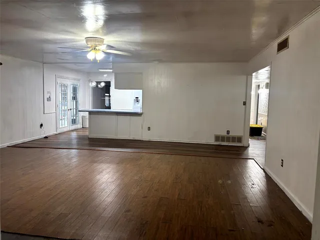 an empty room with wooden floor and chandelier