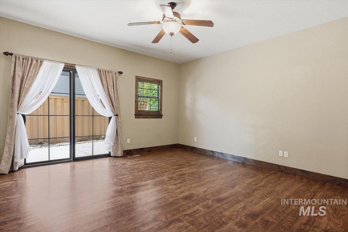 129 East Cholla Hills Street Meridian, ID 83646 - Photo 20 of 33 Room with light-toned carpet flooring, a sliding glass door with grids opening to a balcony with an iron railing, and dark wood trim