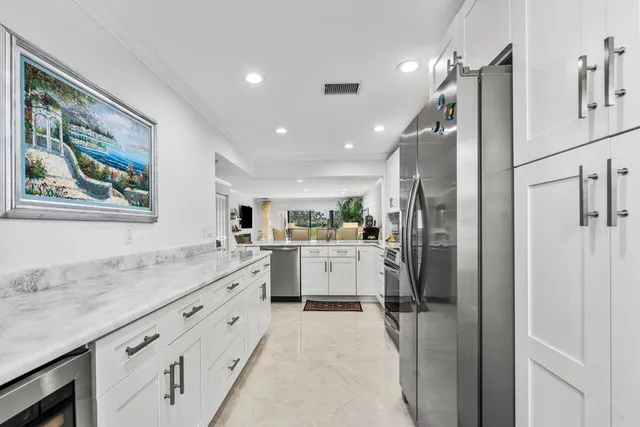 a kitchen with stainless steel appliances granite countertop a refrigerator and a stove top oven
