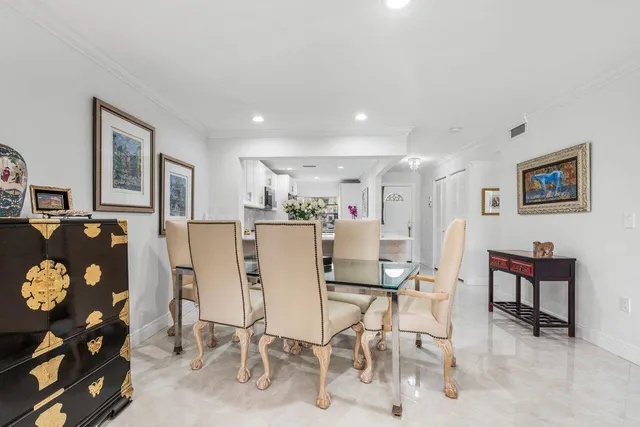 a living room with furniture a dining table and a refrigerator